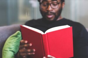 Homem de pele negra lendo um livro, simbolizando a aplicação da lei de cotas