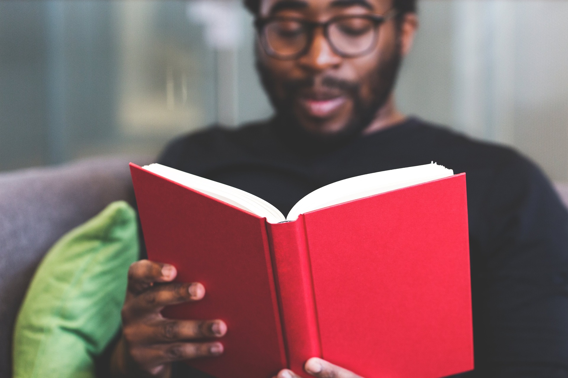 Homem de pele negra lendo um livro, simbolizando a aplicação da lei de cotas